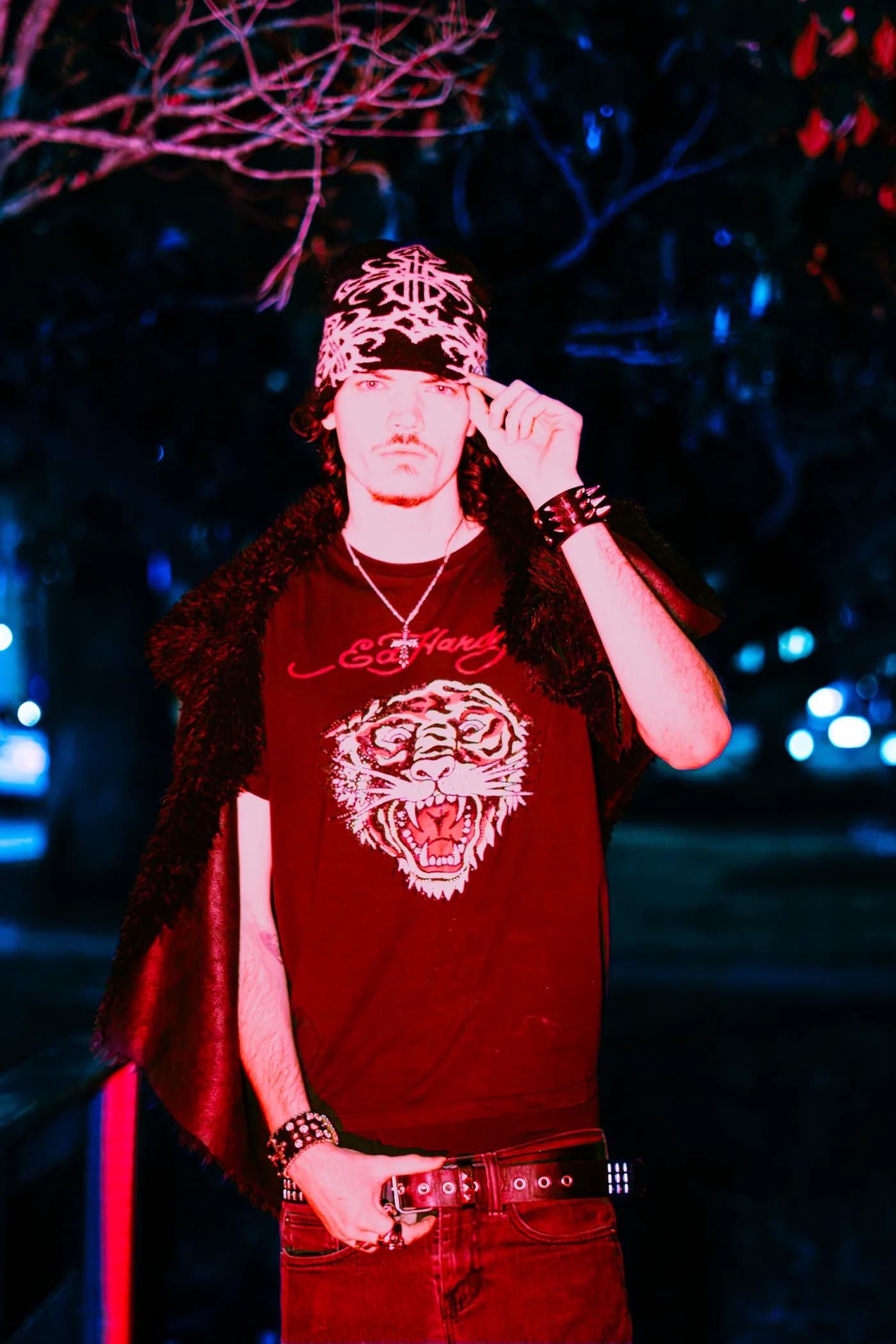 Night portrait at a waterfront, wearing a patterned beanie and a gray skull-print hoodie